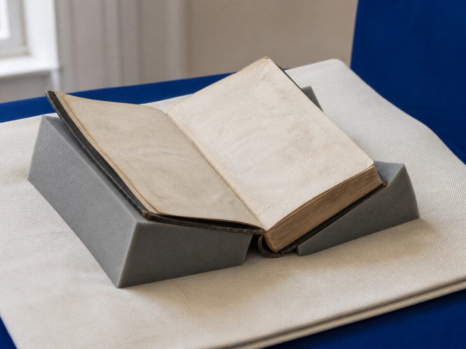 Care for an old missal or prayer book: a devotional object arranged on a worktable
